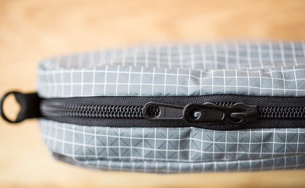 A close-up shot of the zipper on the 3D Organizer Cube showing one of the exterior o-rings.
